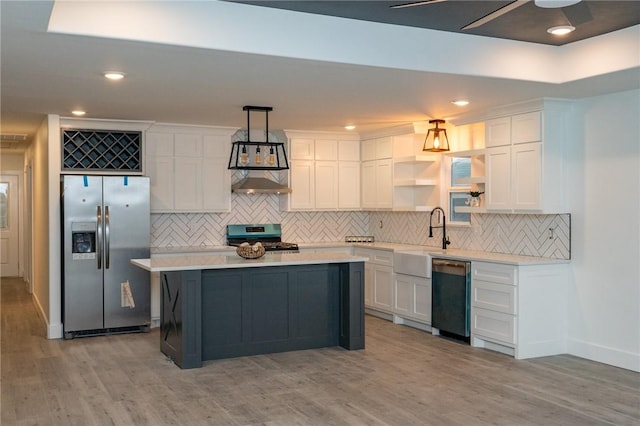 kitchen featuring sink, pendant lighting, stainless steel appliances, light hardwood / wood-style floors, and white cabinets