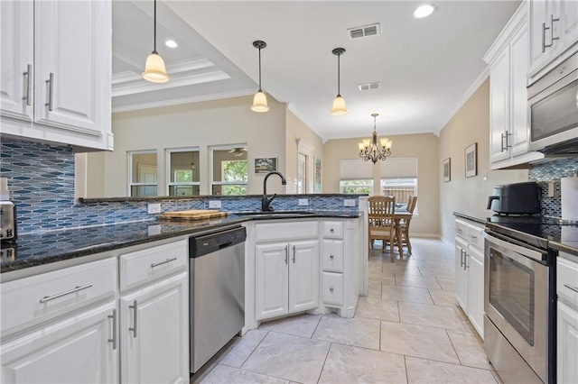 15229 Capstan St, Corpus Christi, TX 78418 - kitchen with appliances with stainless steel finishes, ornamental molding, decorative backsplash, white cabinets, and pendant lighting