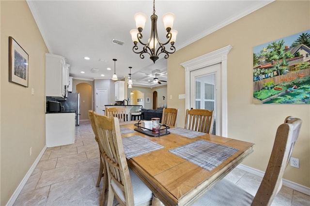 15229 Capstan St, Corpus Christi, TX 78418 - dining area featuring arched walkways, crown molding, a chandelier, stone tile flooring, and a ceiling fan