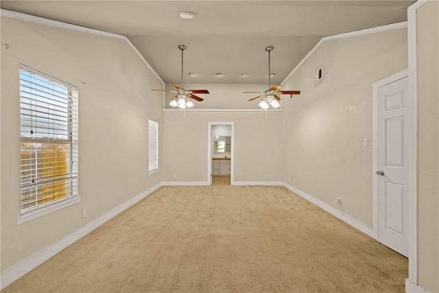 carpeted empty room with ceiling fan, vaulted ceiling, and ornamental molding