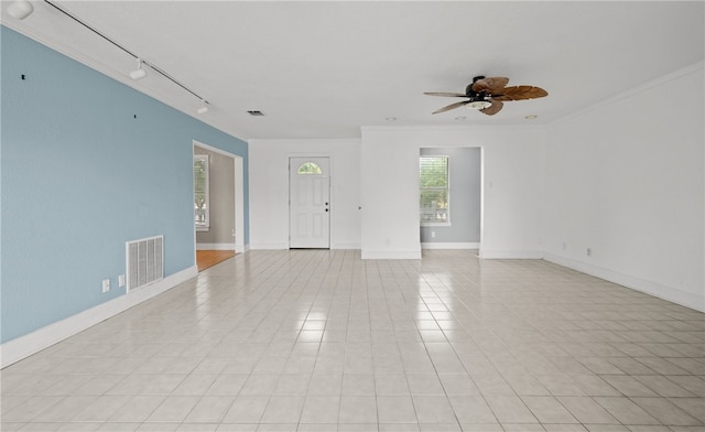 tiled spare room featuring ornamental molding, rail lighting, and ceiling fan