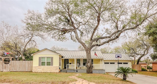 single story home with covered porch, a garage, and a front yard