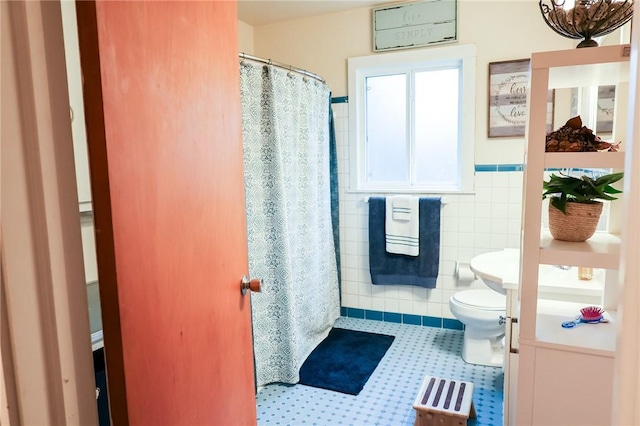 bathroom featuring toilet and tile walls