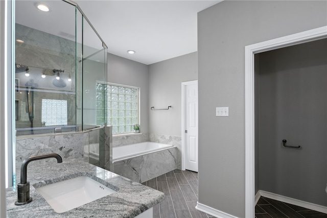 bathroom featuring vanity and shower with separate bathtub