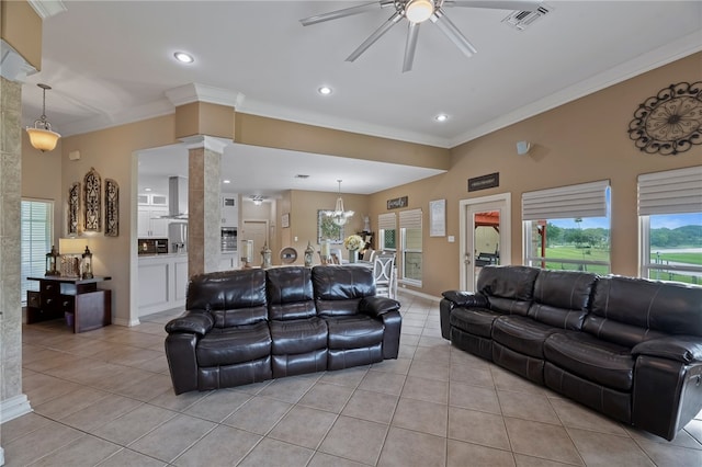 tiled living room with ceiling fan with notable chandelier, ornate columns, and crown molding