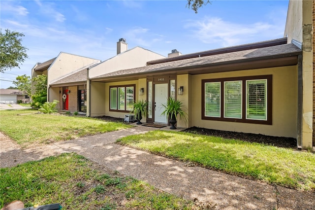 5418 Stonegate Way, Corpus Christi, TX 78411 - view of front facade with a front lawn, stucco siding, and a chimney