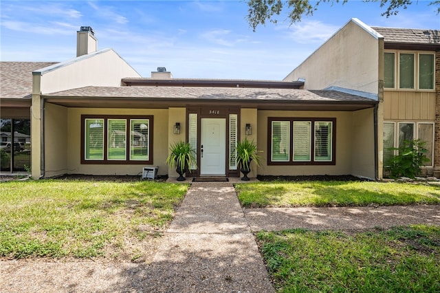 5418 Stonegate Way, Corpus Christi, TX 78411 - view of front of property featuring a chimney, a front yard, stucco siding, and a shingled roof