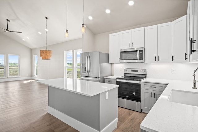 kitchen with white cabinetry, appliances with stainless steel finishes, lofted ceiling, and plenty of natural light