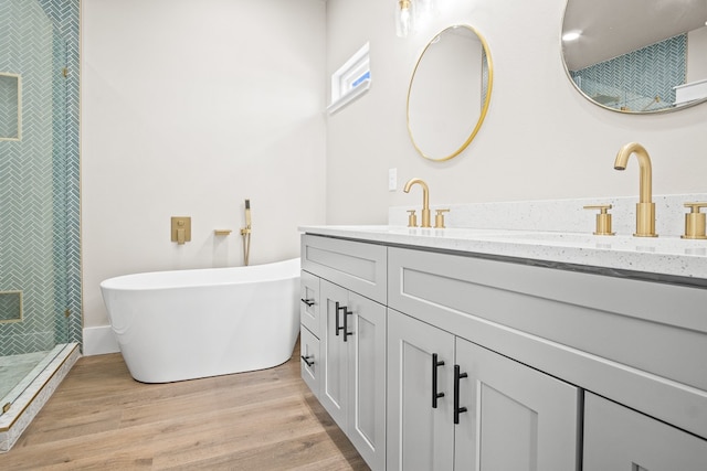 bathroom with wood-type flooring, independent shower and bath, and vanity