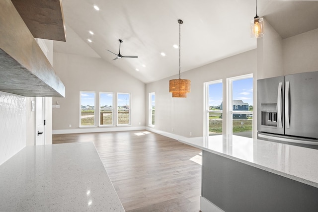 unfurnished living room featuring high vaulted ceiling, ceiling fan, and light hardwood / wood-style flooring