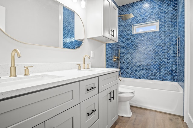 full bathroom featuring toilet, vanity, tiled shower / bath, and hardwood / wood-style floors