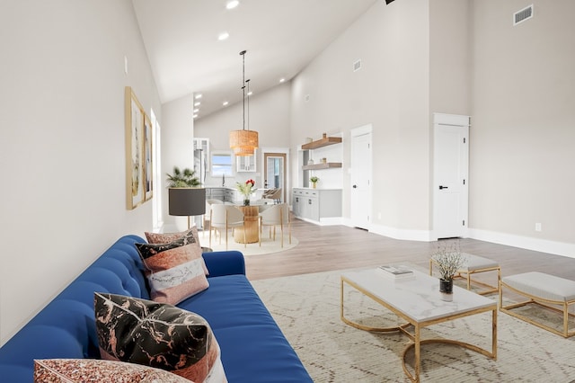 living room with high vaulted ceiling and wood-type flooring