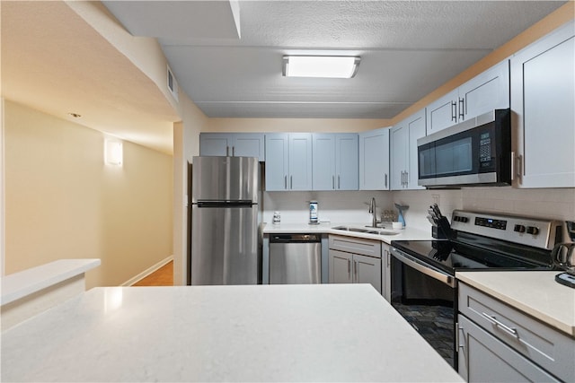 kitchen featuring stainless steel appliances, sink, and tasteful backsplash