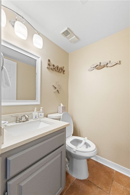 bathroom featuring tile patterned flooring, vanity, and toilet