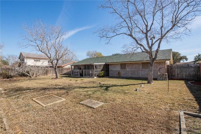 back of property with a sunroom and a yard