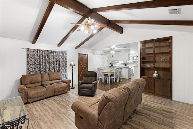 living room with wood-type flooring, lofted ceiling with beams, and ceiling fan