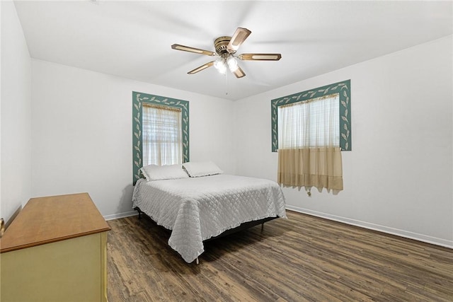 bedroom featuring multiple windows, dark wood-type flooring, and ceiling fan