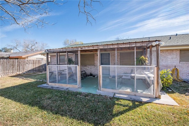 back of house with a yard and a sunroom