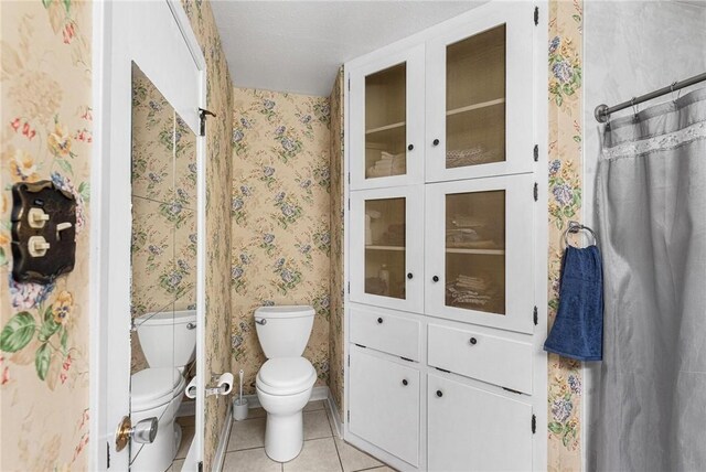 bathroom featuring toilet and tile patterned flooring