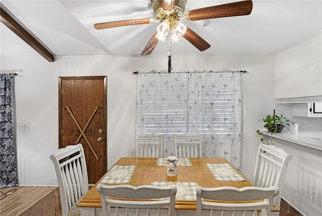 dining space with ceiling fan and beamed ceiling