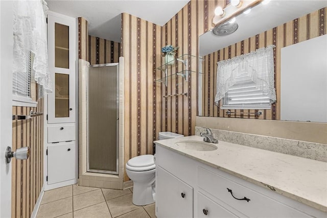 bathroom with tile patterned floors, toilet, a shower with door, and vanity