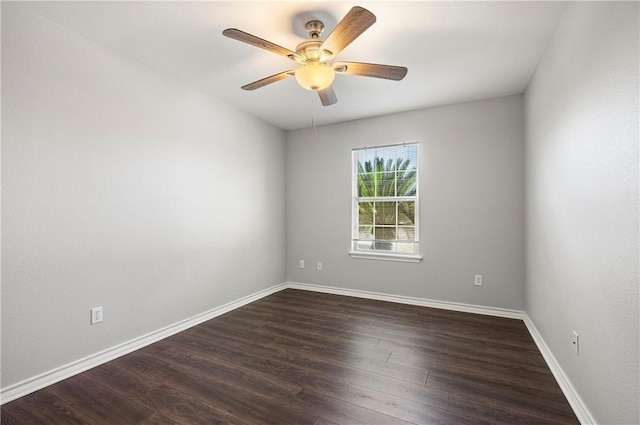 spare room featuring dark wood-style floors, ceiling fan, and baseboards