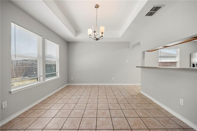 unfurnished room with baseboards, visible vents, a raised ceiling, a notable chandelier, and light tile patterned flooring