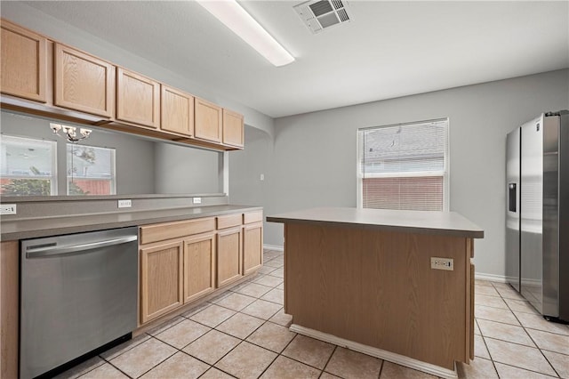 kitchen featuring light tile patterned floors, stainless steel appliances, a kitchen island, visible vents, and light brown cabinetry