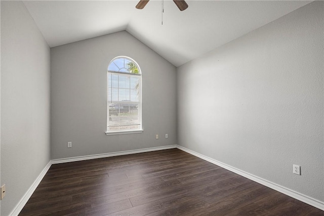 unfurnished room with dark wood-style floors, vaulted ceiling, a ceiling fan, and baseboards