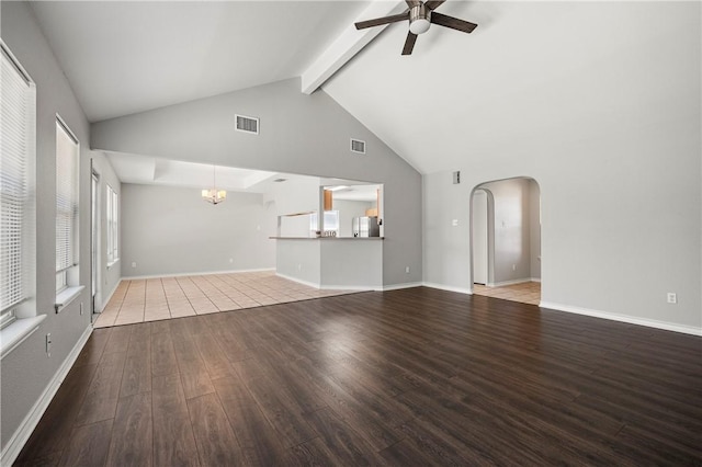 unfurnished living room featuring arched walkways, ceiling fan with notable chandelier, wood finished floors, and visible vents