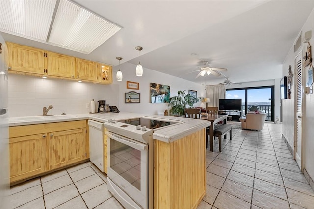 kitchen featuring backsplash, kitchen peninsula, light brown cabinetry, and white appliances