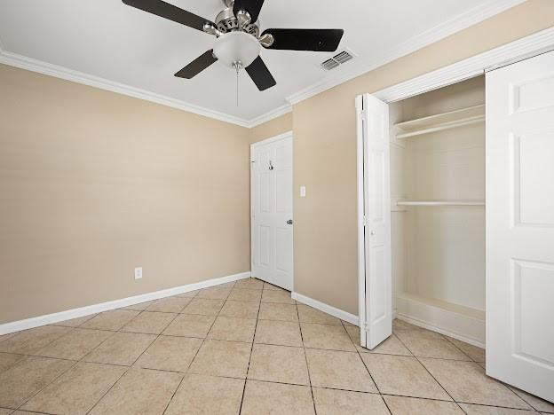 4546 Prescott St, Corpus Christi, TX 78416 - unfurnished bedroom featuring ornamental molding, a closet, a ceiling fan, and light tile patterned flooring