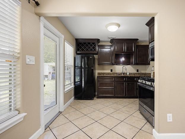 4546 Prescott St, Corpus Christi, TX 78416 - kitchen with appliances with stainless steel finishes, dark brown cabinets, and light tile patterned floors