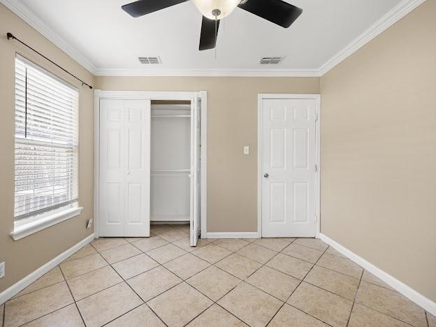 4546 Prescott St, Corpus Christi, TX 78416 - unfurnished bedroom featuring ornamental molding, light tile patterned floors, a closet, and ceiling fan