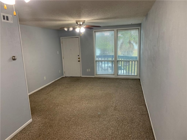 carpeted empty room with ceiling fan and a textured ceiling