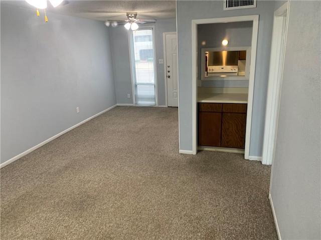 unfurnished room featuring ceiling fan and carpet