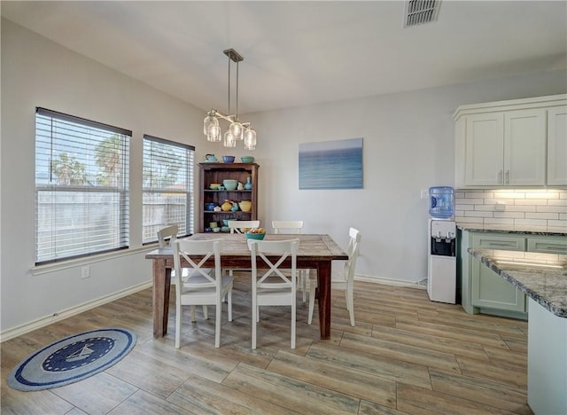 dining room featuring light wood-style flooring and baseboards