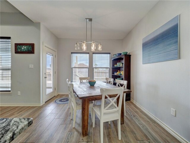 dining space with light wood-style flooring and baseboards