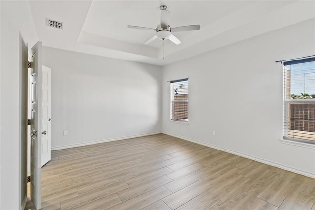 15101 Tesoro Dr, Corpus Christi, TX 78418 - spare room featuring a raised ceiling, plenty of natural light, light wood-style flooring, and ceiling fan