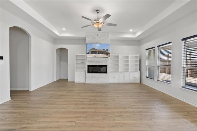 15101 Tesoro Dr, Corpus Christi, TX 78418 - unfurnished living room featuring a raised ceiling, a ceiling fan, light wood finished floors, arched walkways, and recessed lighting