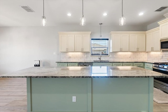 15101 Tesoro Dr, Corpus Christi, TX 78418 - kitchen featuring appliances with stainless steel finishes, dark stone counters, tasteful backsplash, a center island, and recessed lighting