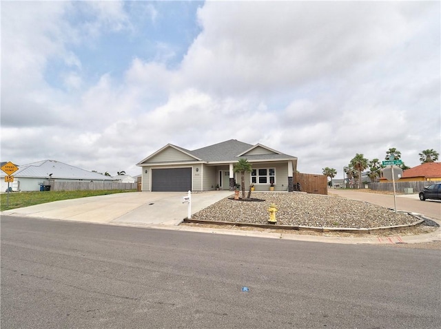 view of front of home with fence, an attached garage, and concrete driveway