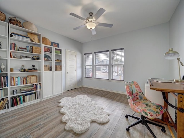 home office with wood finished floors, a ceiling fan, and baseboards