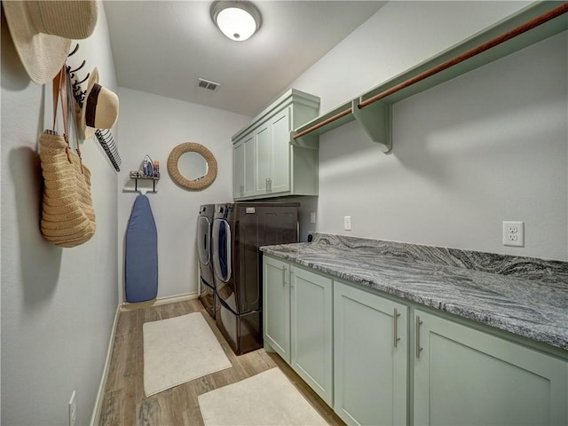 laundry room with washer and dryer, cabinet space, light wood finished floors, and baseboards