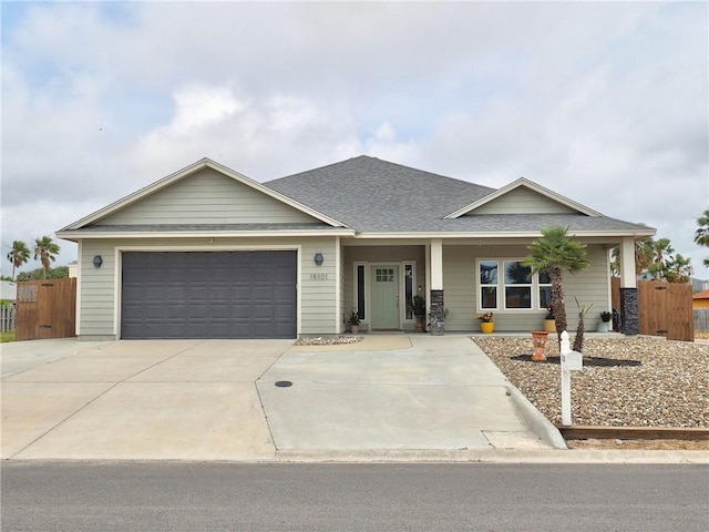 ranch-style house with fence, an attached garage, roof with shingles, concrete driveway, and covered porch