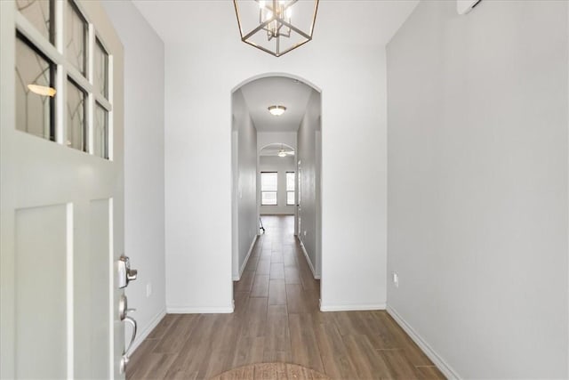 15101 Tesoro Dr, Corpus Christi, TX 78418 - hallway with arched walkways, wood finished floors, and a chandelier