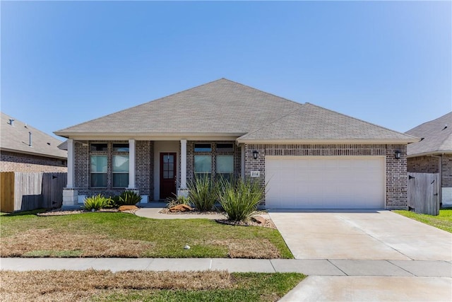 view of front of house featuring brick siding, a front lawn, fence, driveway, and an attached garage