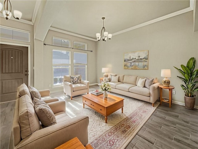 living room featuring hardwood / wood-style flooring, ornamental molding, and an inviting chandelier