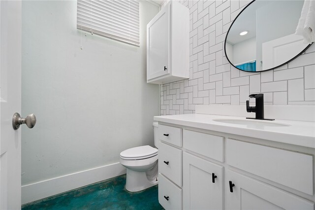 bathroom with toilet, concrete flooring, vanity, and tasteful backsplash