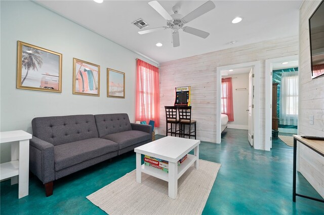 living room featuring wooden walls and ceiling fan